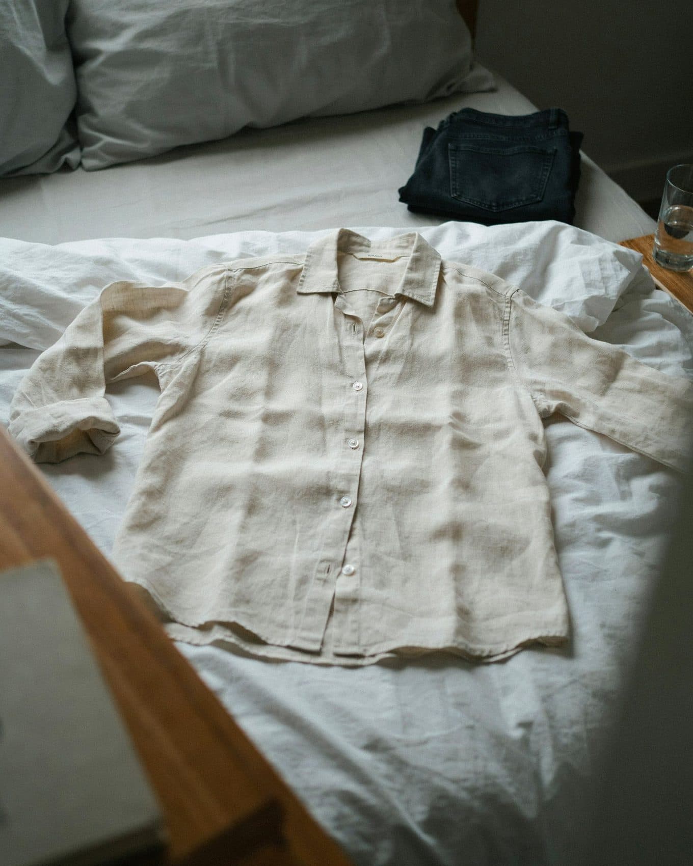 Before: a phone snapshot of a linen shirt lying flat on an unmade bed